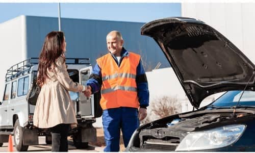 Roadside assistance professional shaking a customers hand